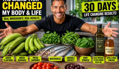Fit, healthy mixed-race man smiling with his arms outstretched over a table filled with green plantains, green bananas, fresh sardines, watercress, arugula, baby spinach, extra-virgin olive oil, apple cider vinegar, cherry tomatoes, and pitted olives in a bright modern kitchen, showcasing the fresh ingredients used in a nutrient-dense sardine and green plantain salad.